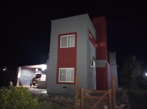メルロにあるEL REFUGIO DE MERLO, alquiler temporarioの夜の赤と白の建物のある小さな家 +6枚の写真