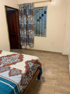 FELIZ ESTADIA Via PRINCIPAL PUERTO LOPEZ في بويرتو لوبيز: غرفة نوم بها سرير ونافذة