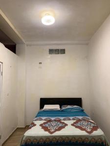 FELIZ ESTADIA Via PRINCIPAL PUERTO LOPEZ في بويرتو لوبيز: غرفة نوم بها سرير في غرفة بيضاء