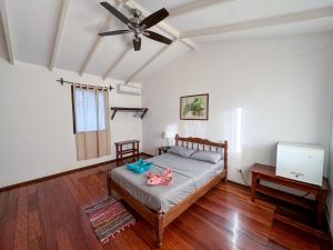 a bedroom with a bed and a ceiling fan at Casa Wolaba in Puerto Viejo