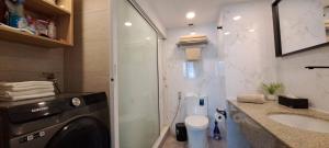 a bathroom with a washing machine and a sink at Stylish New Condo in NANA in Bang Kapi +27 photos