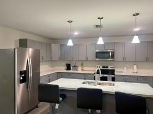 Una cocina con gabinetes blancos y un refrigerador de acero inoxidable. en New 3BR in Central Miami Location for Family & Groups, en Miami 19 fotos más