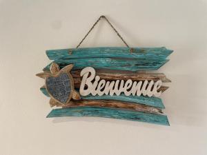 een houten bord met het woord bermite erop, hangend aan een muur bij Couleur Caraibes magnifique T3 Pierre et vacances in Sainte-Luce