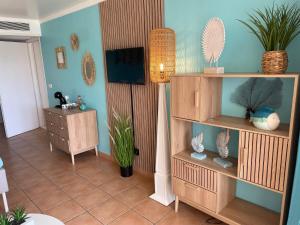 een woonkamer met houten planken en een blauwe muur bij Couleur Caraibes magnifique T3 Pierre et vacances in Sainte-Luce +51 foto's