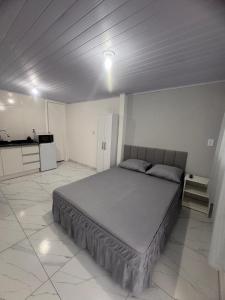een slaapkamer met een groot bed in een kamer bij Studios Cordeiros in Itajaí