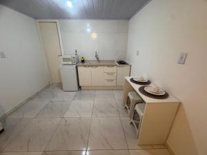 een kleine keuken met een tafel en een magnetron bij Studios Cordeiros in Itajaí