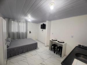 een slaapkamer met een bed en een wastafel bij Studios Cordeiros in Itajaí +8 foto's