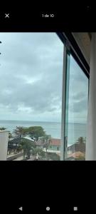 una vista del océano desde una ventana en Suíte na rua da praia, en Porto Belo