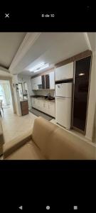 Una sala de estar con un sofá y una cocina. en Suíte na rua da praia, en Porto Belo 5 fotos más