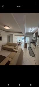 sala de estar amplia con sofás y cocina en Suíte na rua da praia, en Porto Belo