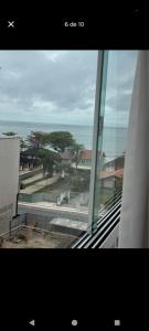 una ventana de un edificio con vistas al océano en Suíte na rua da praia, en Porto Belo