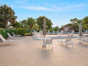 un groupe de chaises et de tables avec parasols dans l'établissement 2 Bedroom 1 Bath Condo, à Fort Myers