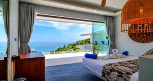 a bedroom with a view of the ocean at BLUE BUTTERFLY Luxury Pool Villa Koh Samui 5 Bedrooms in Koh Samui 