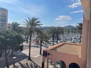 a view of a harbor with palm trees and a building at Studio cabine à Port Argelès avec loggia et parking privatif - FR-1-309-416 in Argelès-sur-Mer