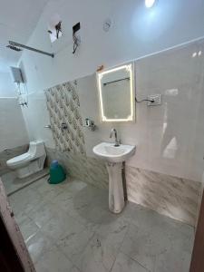 a bathroom with a sink and a mirror and a toilet at Home in the Jungle in Seonī