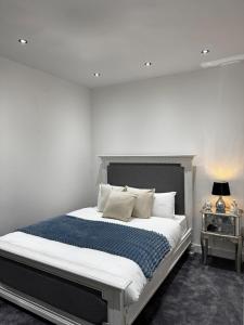 a bedroom with a large bed with white sheets and pillows at The Central Haven in Manchester