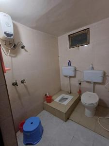 a small bathroom with a toilet and a shower at Shri Nimbark Mohini Kunj in Vrindāvan
