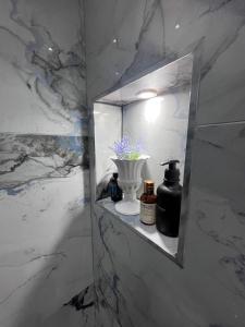a bathroom with a shelf with a vase and a light at The Central Haven in Manchester
