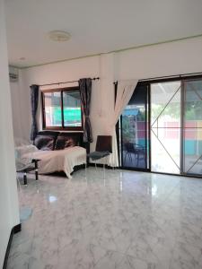 a living room with a bed and a tiled floor at Soi Saliga in Rawai Beach
