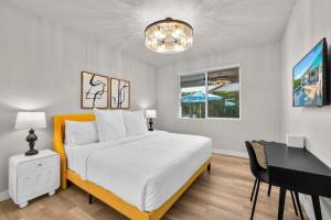 a white bedroom with a bed and a desk and a table at Turquoise Mirage Fun House in Indio +73 photos