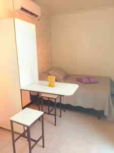 a small room with a bed and a table and a chair at Studio Borboletas de luz in Bombinhas