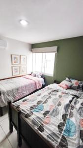 Condominio mzt في مازاتلان: غرفة نوم بها سريرين ونافذة