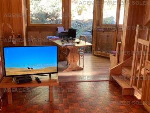 Una sala de estar con un escritorio con televisión y una mesa. en Chalet indépendant confortable pour 6, proche pistes - FR-1-295-212, en Les Angles