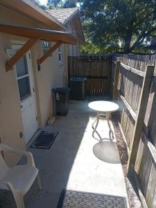 a patio with a table and a bench and a fence at Pinellas Park Oasis in St Petersburg