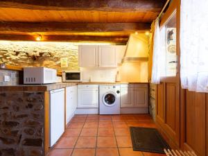 a kitchen with a washer and dryer in a room at Maison pour 5 à Génos proche lac et station avec WiFi - FR-1-695-94 in Génos