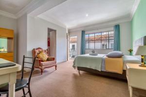 Un dormitorio con una cama, una silla y un escritorio. en Templo de la Luna, en Cusco