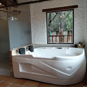 a large white tub in a bathroom with a window at Posada Iglesia Vieja in Soatá +1 photo