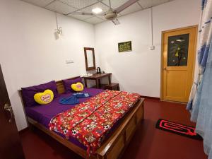 a bedroom with a bed with a colorful blanket on it at DILSHAN HOTEL Diyaluma in Koslanda +32 photos
