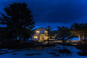 a house lit up at night in the snow at 美瑛の一棟貸切古民家 - Nature Retreat Ubaku Villa in Biei