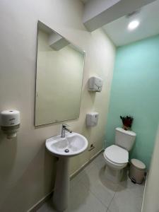 a bathroom with a sink and a toilet and a mirror at Ebratt Inn in Cartagena de Indias