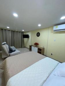 a bedroom with a large white bed and a chair at Ebratt Inn in Cartagena de Indias +9 photos