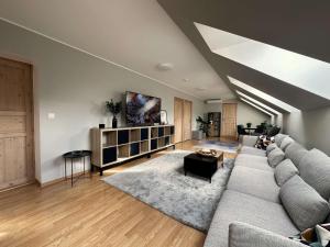 ein Wohnzimmer mit einem großen Sofa und einem Tisch in der Unterkunft Cozy homestay in the suburbs in Saue