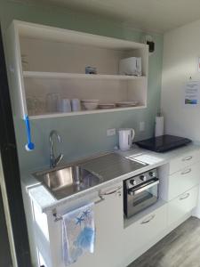a small kitchen with a sink and a counter top at Riverview Studio in Te Puru