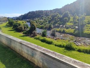 a retaining wall with a river and mountains in the background at Riverview Studio in Te Puru