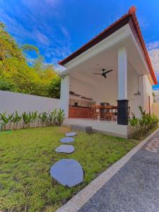 Amitha Lodge Uluwatu في Uluwatu: منزل به حديقة مع خطوات منه +12 صورة