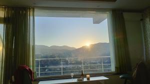 a window with a view of a mountain view at Amazing Valley View in Kasauli +5 photos