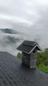 a stone chimney on top of a roof at Amazing Valley View in Kasauli