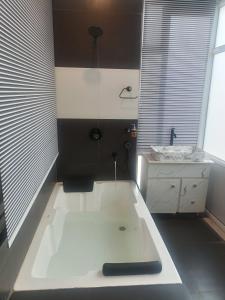 a white bath tub in a bathroom with a sink at Amazing Valley View in Kasauli