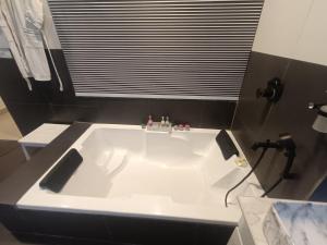 a white bath tub in a bathroom with a window at Amazing Valley View in Kasauli