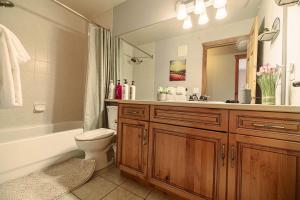 een badkamer met een toilet, een wastafel en een spiegel bij Rocky Mountain Retreat-Mountain View! in Canmore +22 foto's