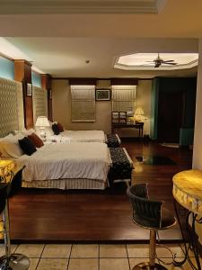 a large bedroom with two beds and a table at Grand Pool Villa Luxury Resort Port Dickson in Port Dickson