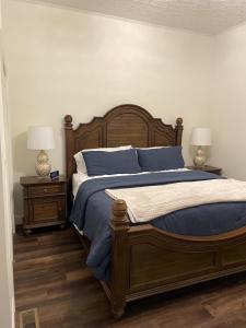 a bedroom with a bed with blue sheets and two lamps at Historic Market Plaza Overlook in Wheeling