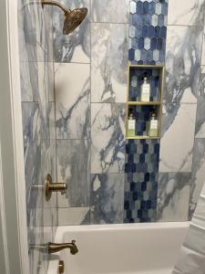 a bathroom with a shower with blue and white tiles at Historic Market Plaza Overlook in Wheeling