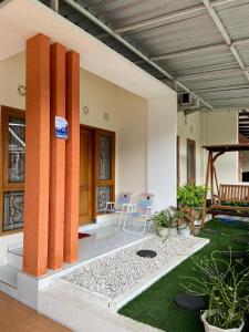 Una sala de estar con sillas y plantas en un edificio. en Serayu Jaraksari Homestay, en Wonosobo