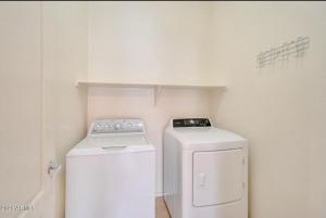 a small white laundry room with a washer and dryer at nice home in Chandler