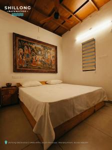 エルナクラムにあるShillong Backwatersの壁に絵が飾られたベッドのある寝室 +8枚の写真